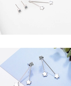 Macro shot of silver star fringe earrings with zircon studs and removable pendants