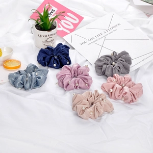 Détail de chouchous en satin de soie aux tons Morandi avec perles blanches