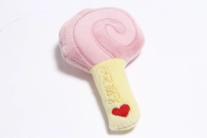 Detail of plush lollipop toy with heart embroidery and 'Baby' text on soft pink fabric