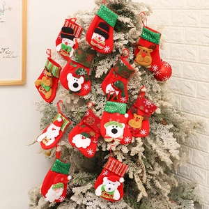 Mini Christmas stockings with Santa and Snowman hanging on a festive snowy tree