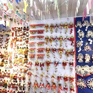 Detailed wall display of various red and gold plastic Christmas bells and festive ornaments