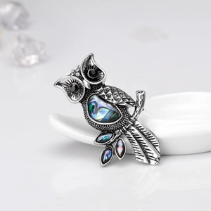 Detailed close-up of a vintage owl brooch featuring natural abalone shell and black rhinestones