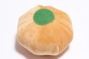 Top view detail of soft plush pumpkin pet toy with green leaf and orange velvet texture