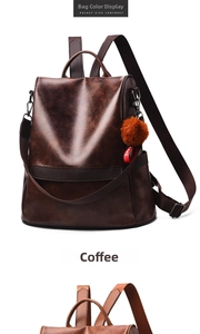 Detail view of coffee brown faux leather backpack with plush ball charm and side pocket