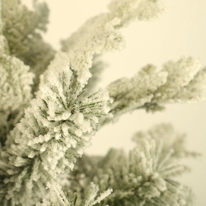 Lush flocked artificial Christmas pine branches with realistic snow-covered pine needles
