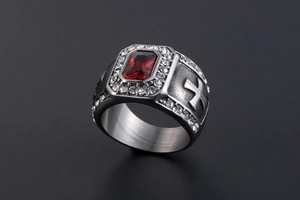 Gros plan détaillé d'une bague rétro argentée avec grande pierre rouge et croix