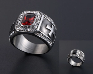Détail d'une bague vintage avec pierre rouge et motif de croix gravé sur le côté