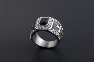 Gros plan détaillé d'une bague à pierre noire carrée avec motifs de croix et cristaux