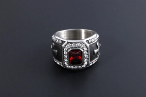 Macro d'une bague en argent avec pierre rouge et gravures de croix latérales