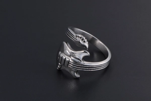 Macro detail of silver guitar-shaped stainless steel ring showing its polished metal texture