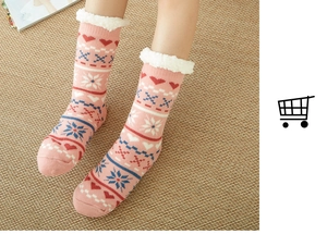 Detail of pink knitted winter floor socks with white fleece lining and snowflake patterns