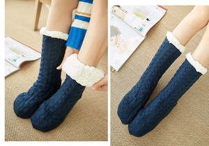 Detail of warm navy knit slipper socks with thick fleece lining and white plush cuffs