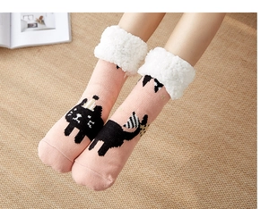 Close-up of pink thermal floor socks with black cat pattern and white fleece lining