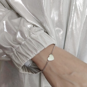 Minimalist 925 sterling silver heart charm bracelet shown on a model wrist detail