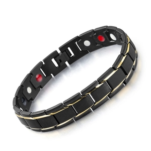 Macro shot of black and gold magnetic therapy bracelet with inset circular elements