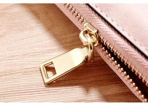 Macro shot of smooth gold-tone zipper hardware on a premium pink long wallet for women