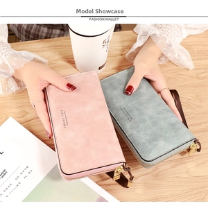 Close-up of pink and grey long zipper wallets with hand strap in a lifestyle scene