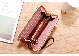 Detailed interior of a pink leather long wallet featuring multiple card slots and a wrist strap