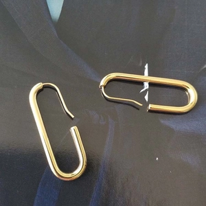 Orecchini rettangolari minimalisti placcati oro su un abito blu scuro elegante