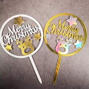 Detail of white and gold Merry Christmas cake toppers with reindeer and star patterns