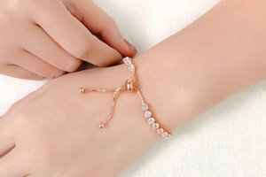 Detail of rose gold tennis bracelet featuring adjustable slider clasp and cubic zirconia