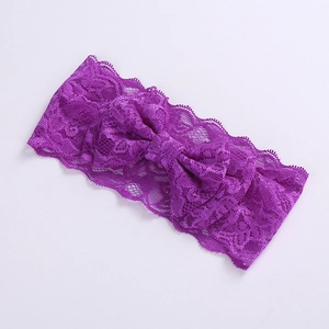 Close-up of a purple lace headband featuring a large bow and delicate wavy edge textures