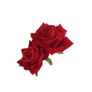 Close-up of dual red velvet artificial roses with green leaves for hair styling