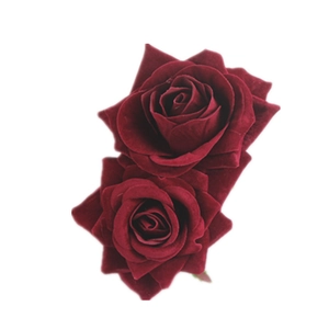 Macro detail of two burgundy velvet rose hair clips with realistic petal textures