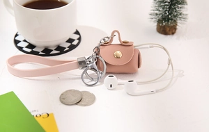 Pink faux leather mini coin pouch with snap closure and long strap for earphone storage