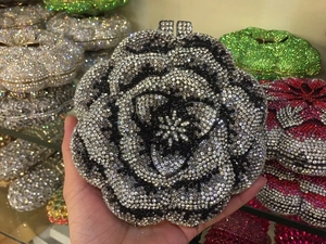 Macro shot of 3D camellia evening clutch with sparkling black and white rhinestones