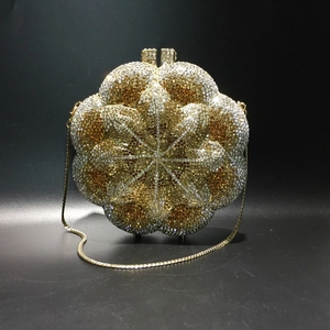 Close-up of sparkling floral rhinestone evening clutch with gold metal chain strap