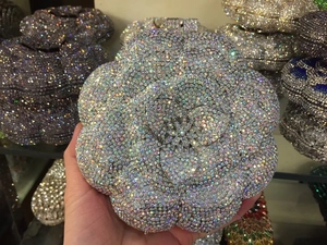 Detailed view of silver camellia flower clutch bag with sparkling crystal rhinestones