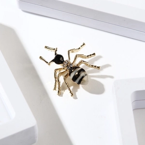 Broche fourmi dorée élégante avec rayures émaillées et strass sur un support blanc