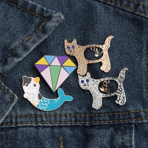 Set di quattro spille in smalto gatto sirena e diamante su tasca di jeans