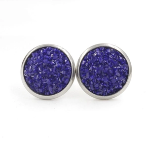 Gros plan sur les boucles d'oreilles en résine bleu foncé avec un cadre métallique argenté