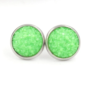 Vue macro de boucles d'oreilles rondes en résine vert citron avec base en acier argent