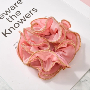 Detail of pink chiffon scrunchie with layered pleats and gold stitched edge finish
