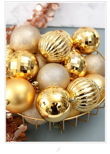 Detail of assorted gold Christmas baubles in matte, glitter, and ribbed textures in a basket