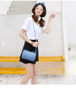 Detailed view of sky blue lychee grain leather mini handbag with elegant bow decoration