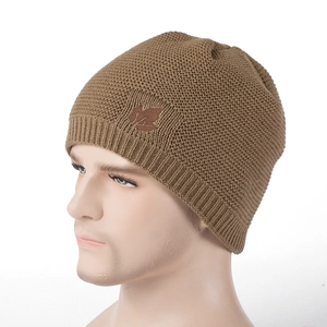 Detail of brown knit beanie showing maple leaf patch and ribbed cuff on mannequin