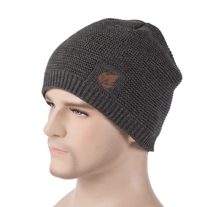 Detail of dark grey knit beanie featuring a brown maple leaf leather patch on a side view