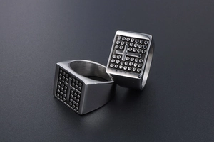 Detail of two vintage stainless steel rings with cross relief and dotted texture