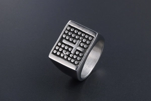 Macro view showing the stainless steel cross pattern and dotted texture on wide mens ring