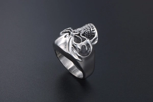 Detailed close-up of a silver skull ring with hollow carvings and metallic luster finish