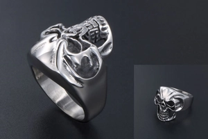 Macro shot of silver skull ring showing intricate carvings and side profile details