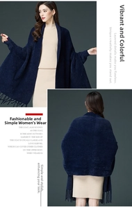 Detail view of dark blue knit poncho with fringe and soft faux mink texture for autumn