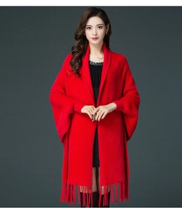 Detail of red knit shawl with fringed hem and soft faux mink texture for winter wear