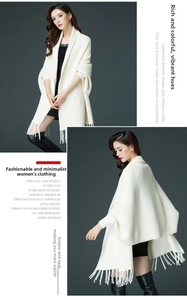 Detail view of cream knit shawl with elegant long fringe hem and thick texture