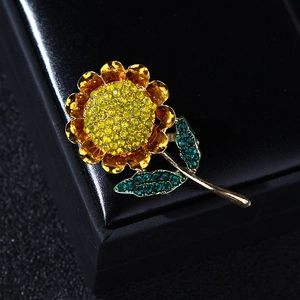 Close-up of sunflower brooch with yellow and green crystals on a black leather case