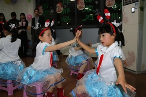 Kids wearing Christmas outfits with white tops, blue sequin skirts and reindeer headbands